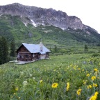 Log House in flowers with mtn